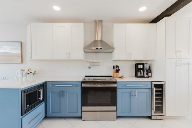 kitchen featuring beverage cooler, stainless steel appliances, wall chimney exhaust hood, and light countertops