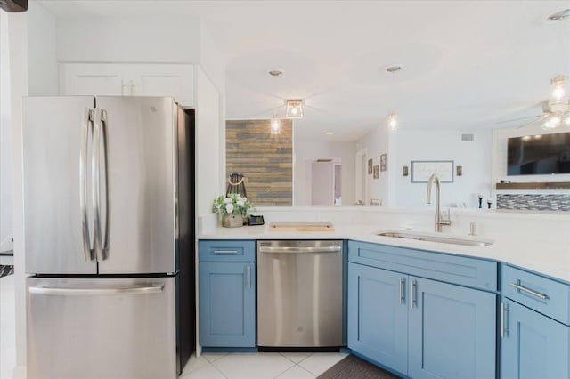 kitchen with a sink, stainless steel appliances, light tile patterned floors, and light countertops