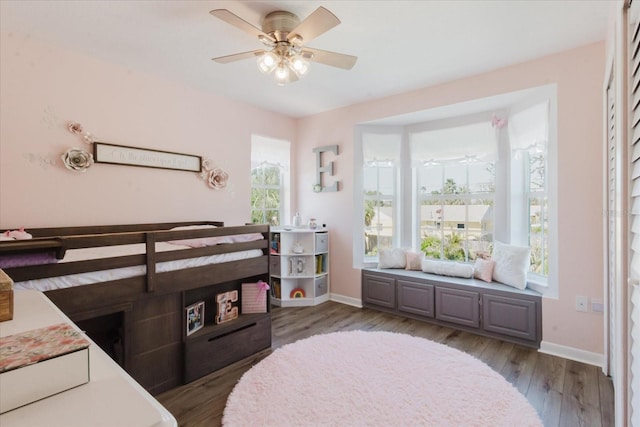 bedroom with ceiling fan, baseboards, and wood finished floors