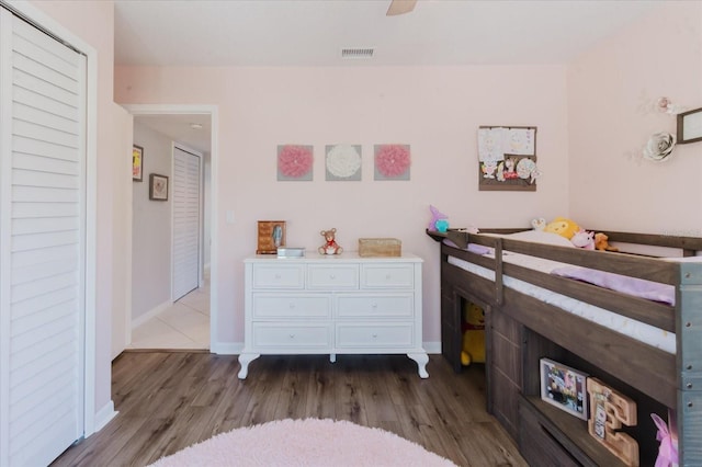 bedroom with visible vents, ceiling fan, baseboards, and wood finished floors