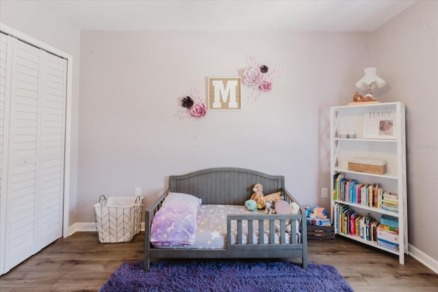 bedroom featuring a closet, baseboards, and wood finished floors