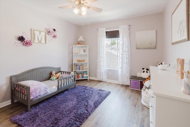 bedroom with ceiling fan, baseboards, and wood finished floors