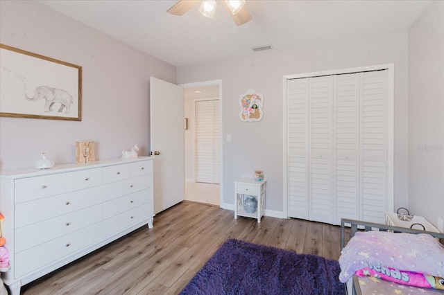 bedroom with visible vents, light wood-style flooring, a closet, baseboards, and ceiling fan