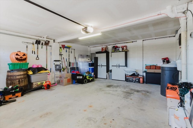 garage featuring concrete block wall and a garage door opener