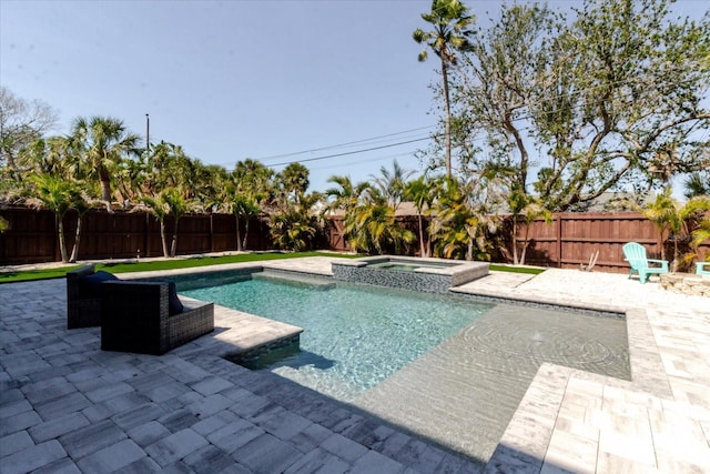 view of pool featuring a patio area, a pool with connected hot tub, and a fenced backyard