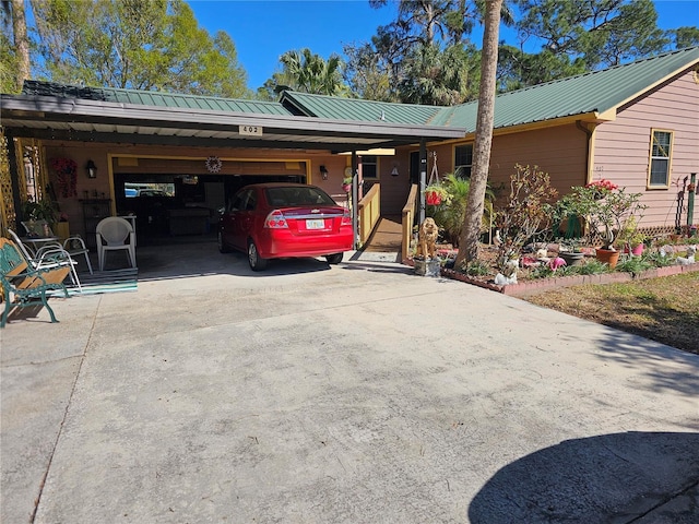 ranch-style home with an attached carport, driveway, and metal roof