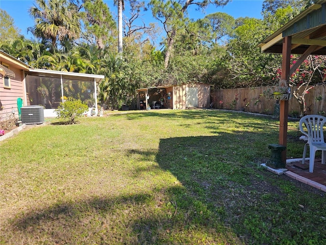 view of yard featuring an outdoor structure, central AC unit, a fenced backyard, and a shed