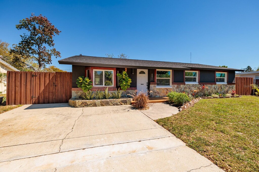 8871 94th St, Seminole, FL 33777 - single story home featuring stucco siding, fence, a front yard, and a gate