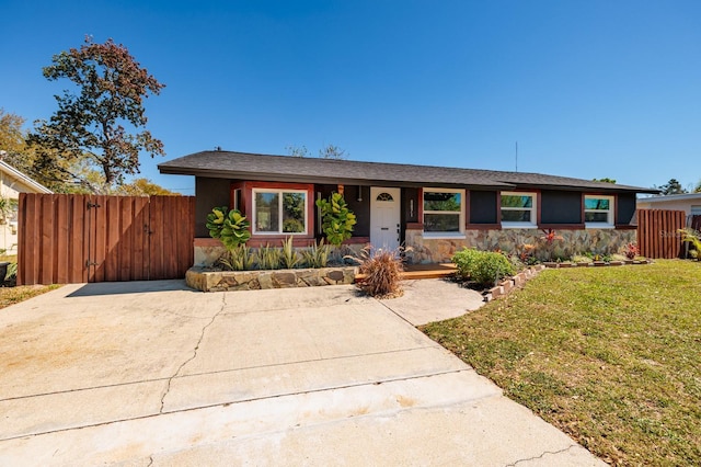 single story home featuring stucco siding, fence, a front yard, and a gate