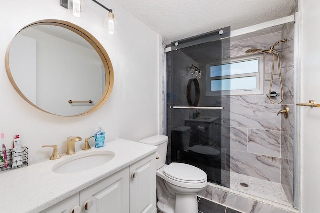 bathroom with toilet, a stall shower, vanity, and a textured ceiling