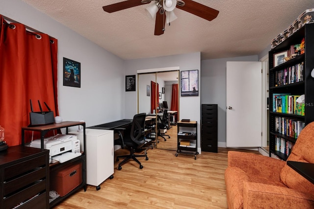 office area featuring light wood finished floors, a textured ceiling, and a ceiling fan