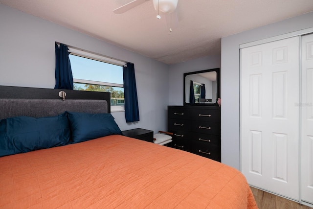 bedroom with a closet, wood finished floors, and a ceiling fan