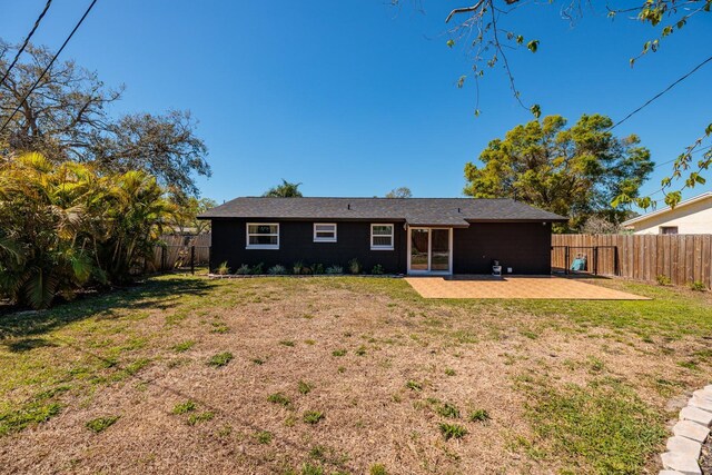 rear view of house with a yard, a fenced backyard, and a patio