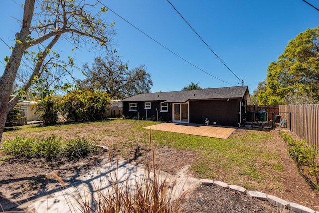 rear view of property featuring a yard, a patio area, and a fenced backyard