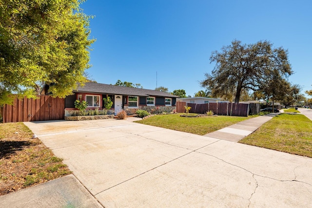 single story home with a front lawn and fence