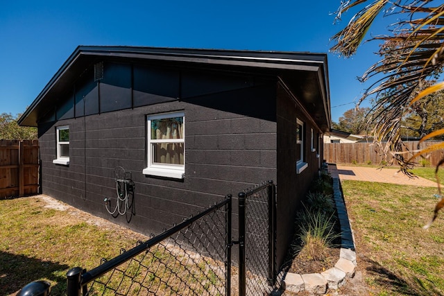 view of side of home featuring a yard and a fenced backyard