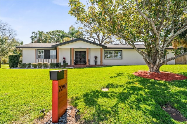 ranch-style home with stucco siding and a front yard