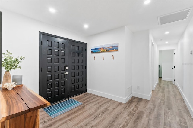 foyer entrance featuring visible vents, recessed lighting, baseboards, and wood finished floors