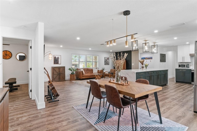 dining room with electric panel, recessed lighting, baseboards, and light wood finished floors