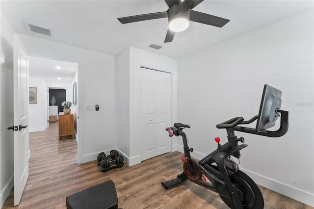 exercise room featuring visible vents, baseboards, and wood finished floors