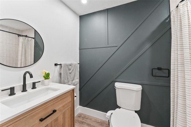 bathroom featuring toilet, vanity, and a shower with curtain