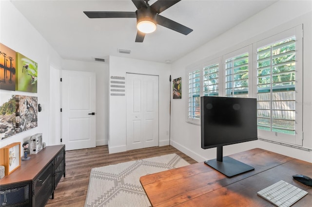 office area featuring visible vents, baseboards, wood finished floors, and a ceiling fan