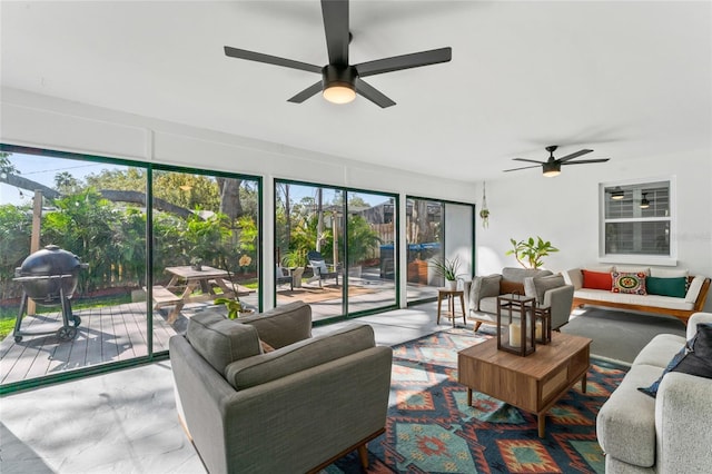 living room featuring ceiling fan and a sunroom