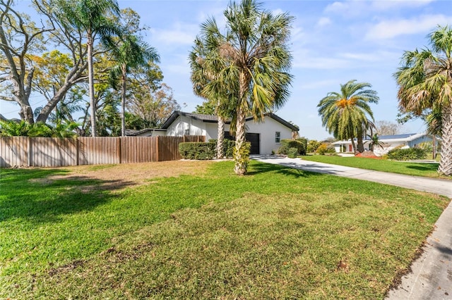 exterior space with a front yard, an attached garage, driveway, and fence