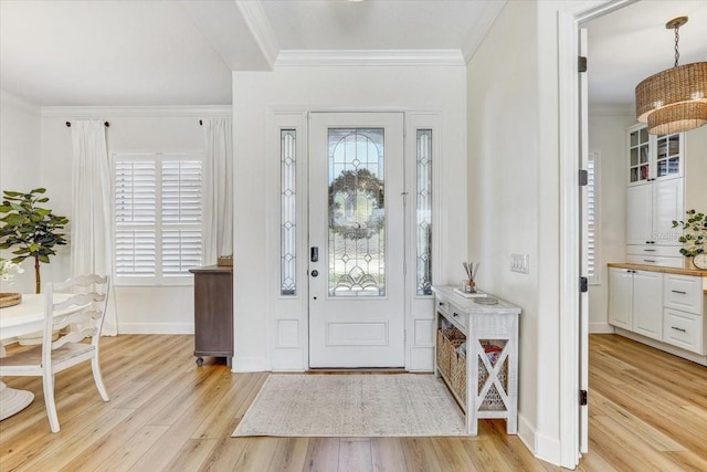 foyer with baseboards, light wood-style flooring, and crown molding