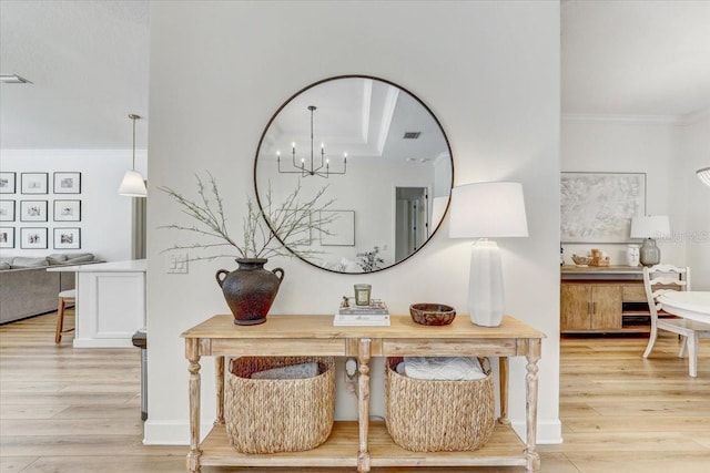 interior details featuring a chandelier, wood finished floors, and crown molding