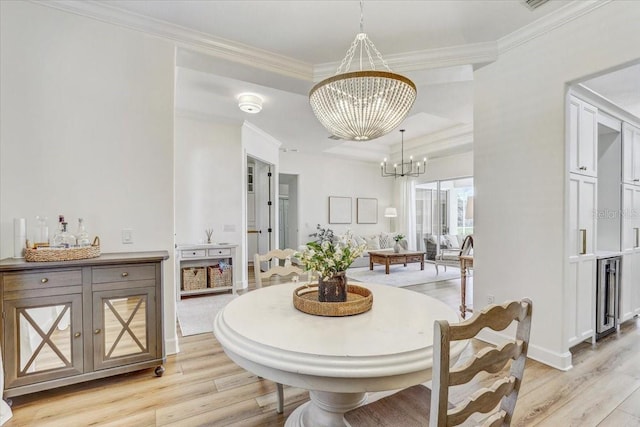 dining room with baseboards, light wood-style floors, an inviting chandelier, and crown molding