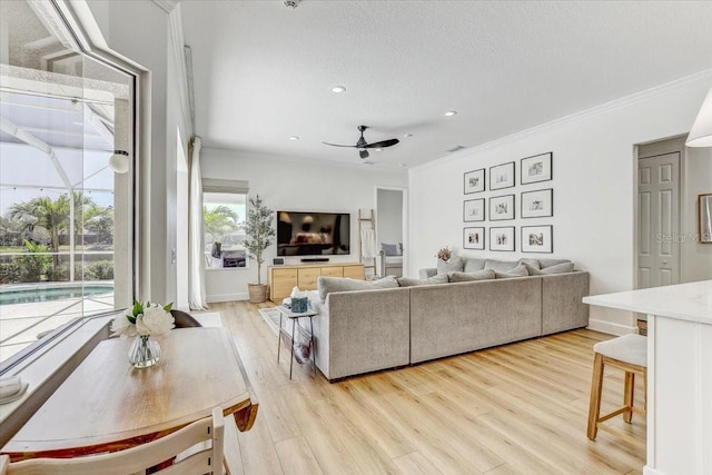 living room featuring ornamental molding, light wood-style floors, recessed lighting, and ceiling fan