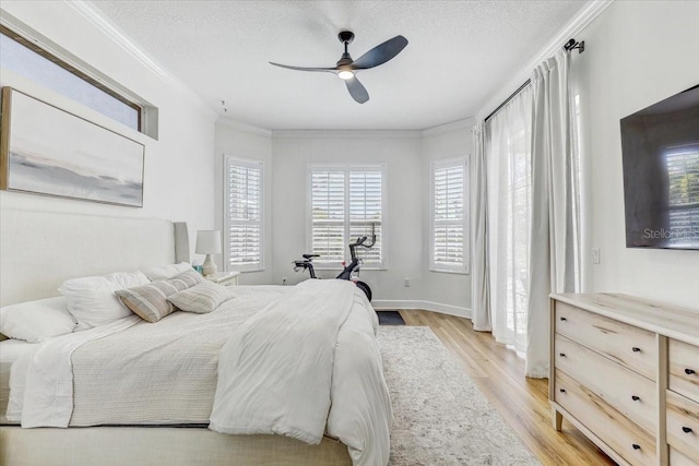 bedroom with light wood-type flooring, baseboards, a textured ceiling, and crown molding