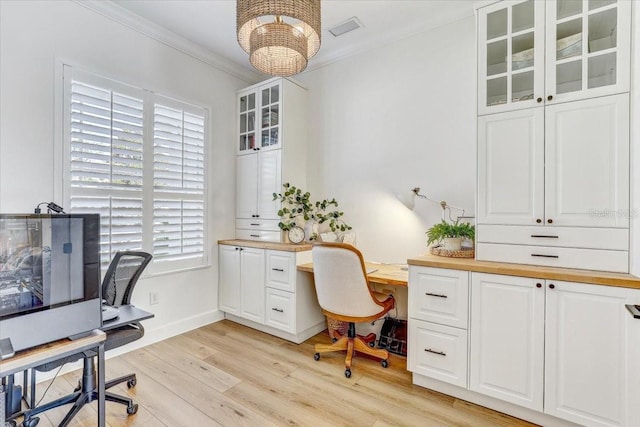 home office featuring visible vents, baseboards, an inviting chandelier, light wood-style floors, and crown molding