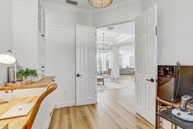 corridor featuring crown molding, visible vents, light wood-type flooring, and a chandelier