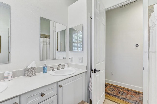 bathroom featuring double vanity, visible vents, and a sink