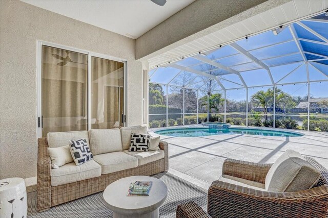 view of pool featuring glass enclosure, an outdoor hangout area, a pool with connected hot tub, and a patio