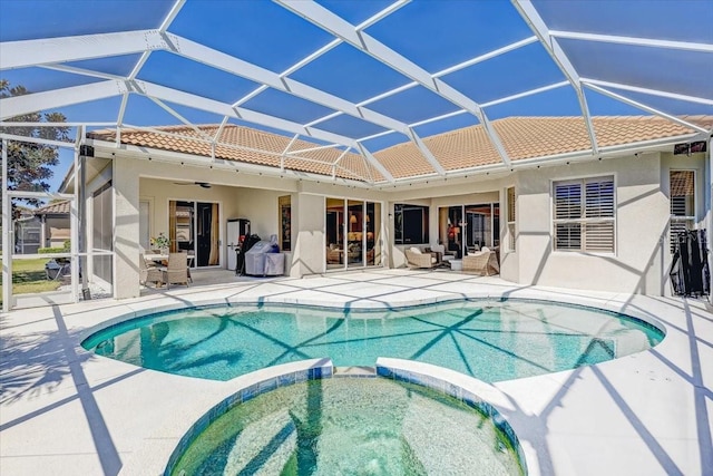 view of pool featuring a patio area, a ceiling fan, and a pool with connected hot tub