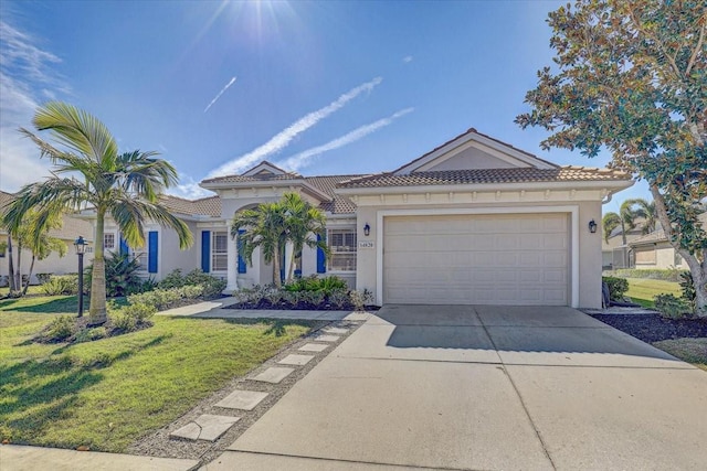 view of front of property featuring stucco siding, concrete driveway, a front yard, an attached garage, and a tiled roof