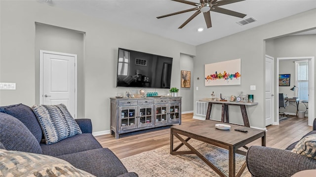 living room featuring visible vents, baseboards, recessed lighting, light wood-style floors, and a ceiling fan