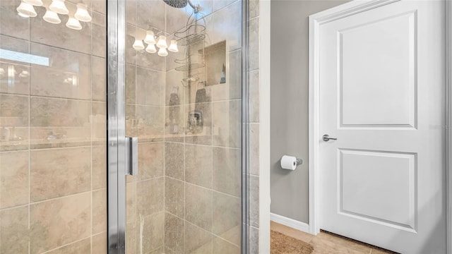 full bathroom with a shower stall, baseboards, and a chandelier