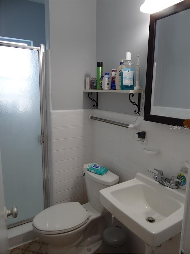 full bathroom with a shower stall, toilet, wainscoting, and a sink