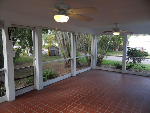 unfurnished sunroom with ceiling fan