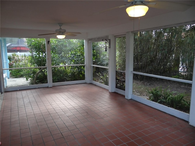 unfurnished sunroom featuring a ceiling fan