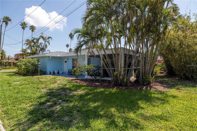 back of property with a lawn and stucco siding