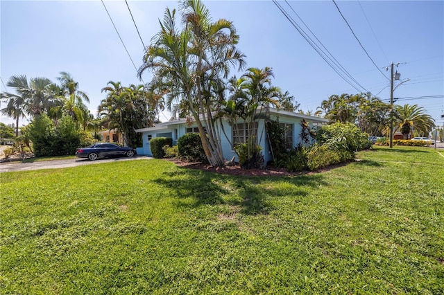 view of front facade with concrete driveway and a front lawn