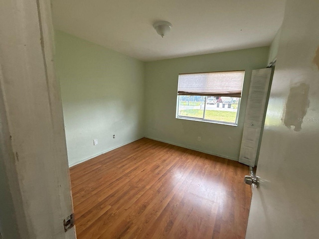 unfurnished bedroom featuring baseboards and wood finished floors