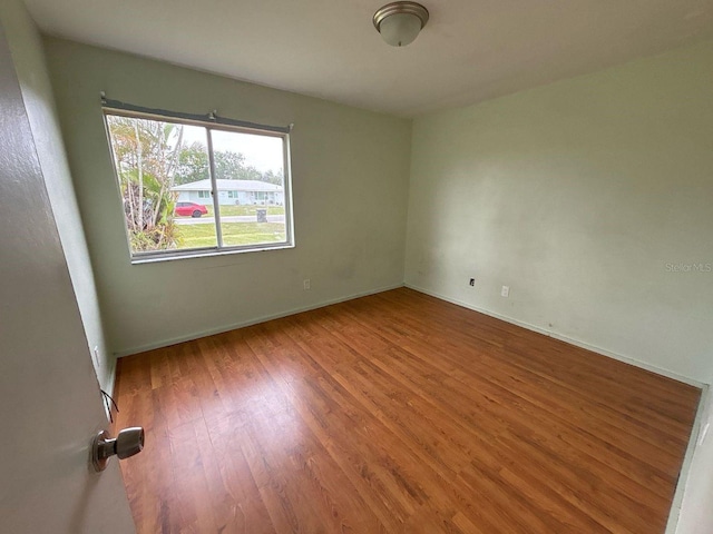 empty room featuring baseboards and wood finished floors
