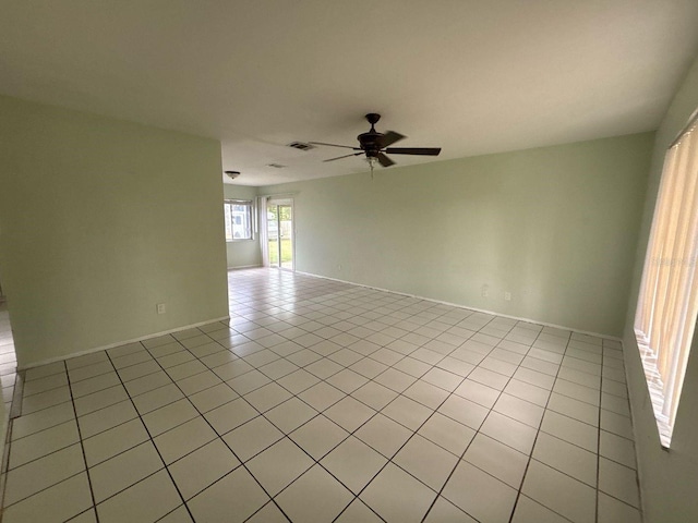 spare room with light tile patterned flooring, visible vents, and ceiling fan