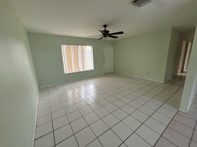 spare room featuring light tile patterned floors, visible vents, baseboards, and a ceiling fan